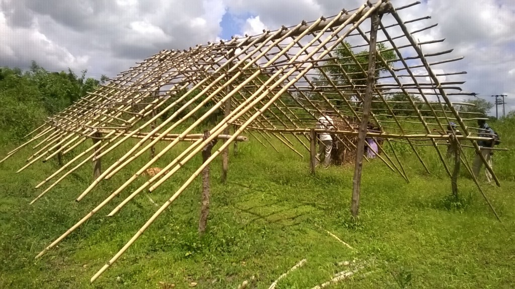 Villagers erect the roof of the provisional school building.
